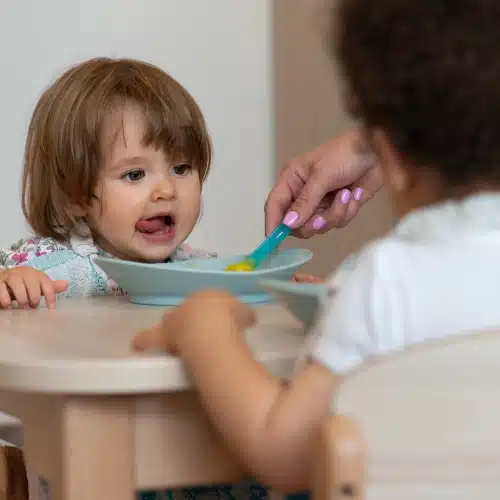 petite fille qui mange en crèche